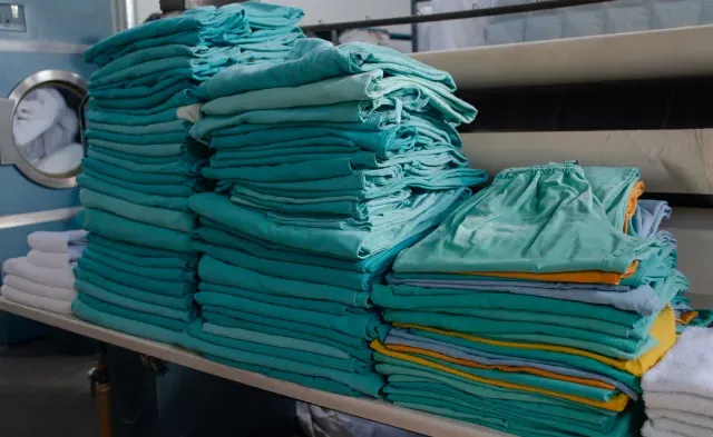 Stack of modern day green scrubs neatly folded in a pile